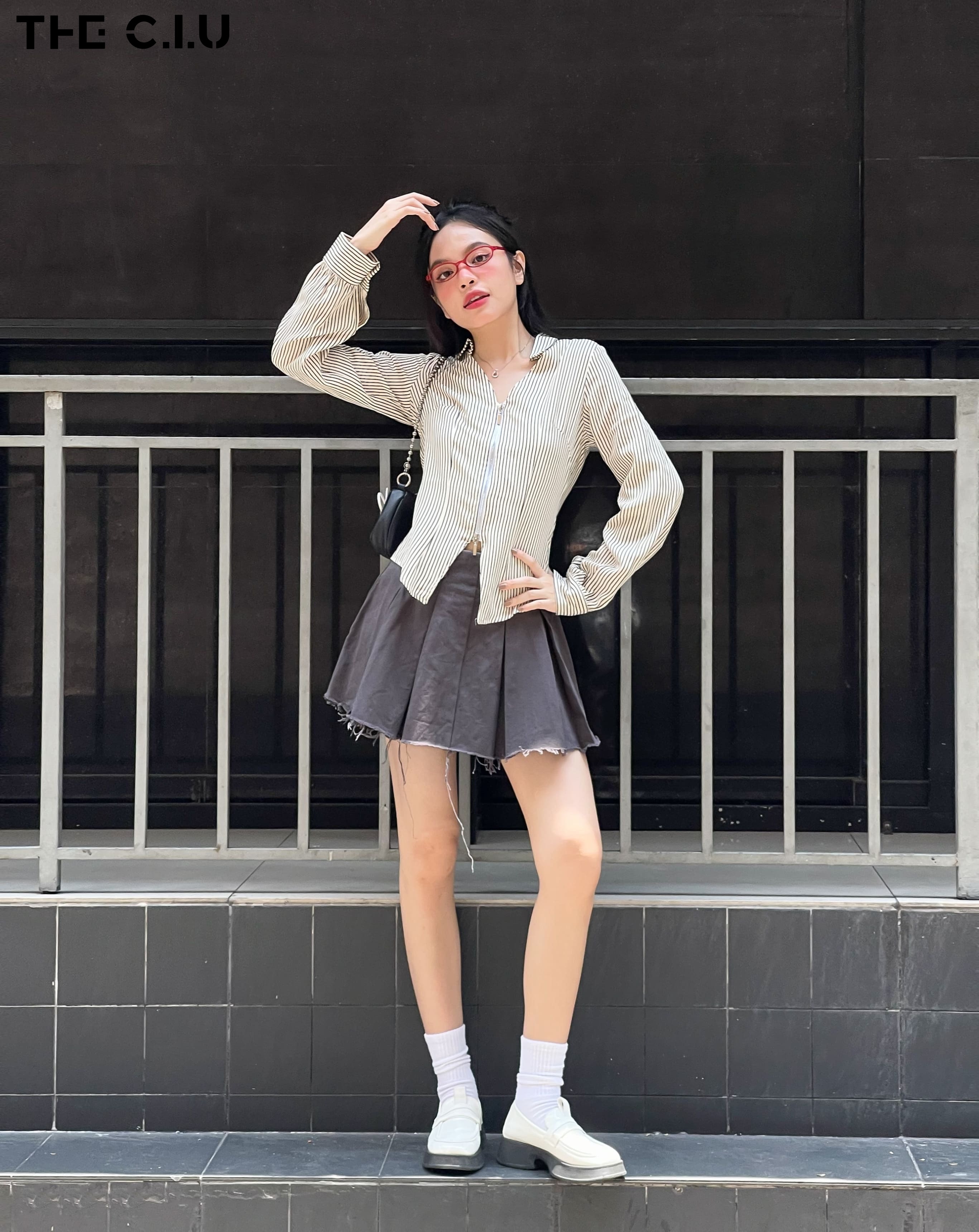 Áo sơ mi phối với chân váy ngắn tạo nên tổng thể outfit trẻ trung, thanh lịch