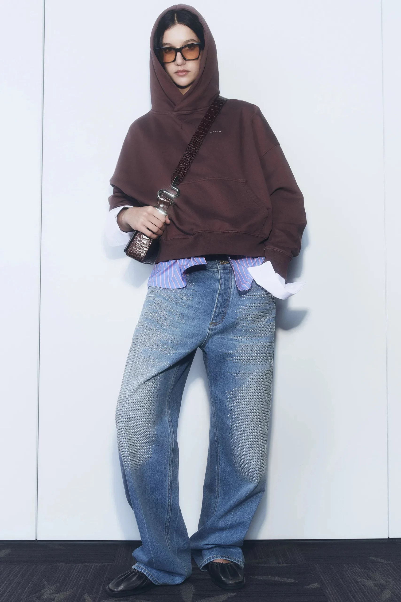 Tổng thể outfit của mẫu mặc cực kì đơn giản, nhưng điểm nhấn là chiếc sơ mi bên trong lộ ra ngoài, khiến hoodie trông phá cách và có điểm nhấn hơn hẳn